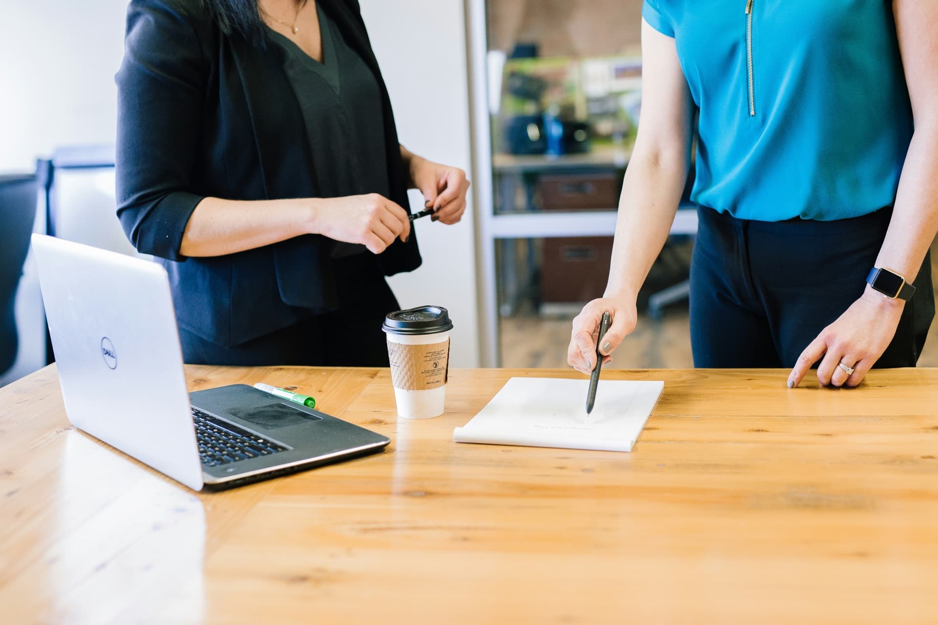 Ordinateur portable ouvert sur une table de travail, plan d'action et tasse de café